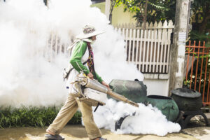 Man is using thermal fog machine to protect mosquito spreading